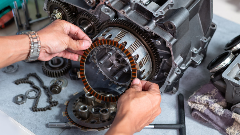 Mechanic removing a clutch plate.