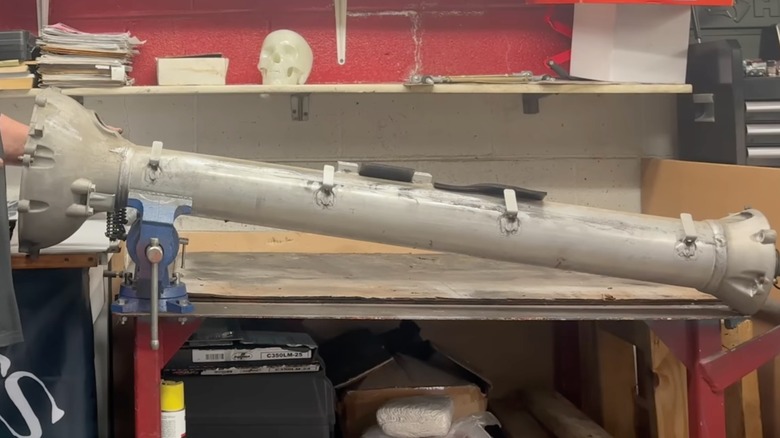 A clean torque tube sitting on a work bench.