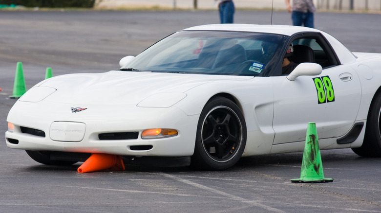 یک کوروت C5 سفید روی یک مخروط نارنجی در یک رویداد اتوکراس رانندگی می کند.