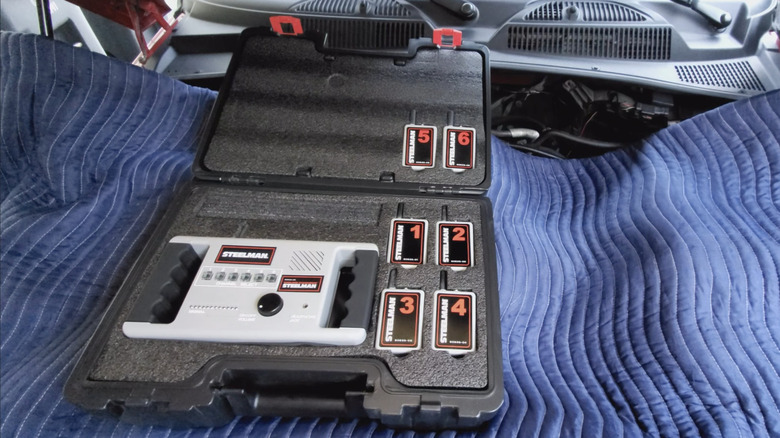 A wireless ChassisEAR kit, under the hood of a vehicle on a blue blanket.