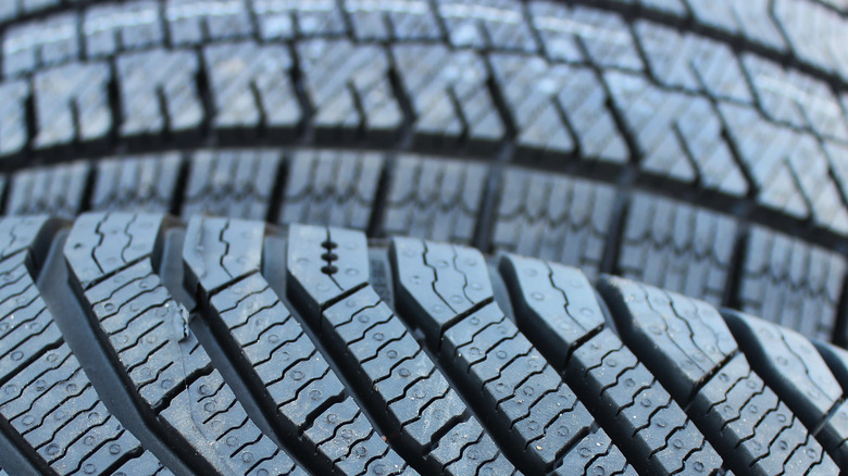 Close-up view of the many sipes or slits on the treads of a new tire