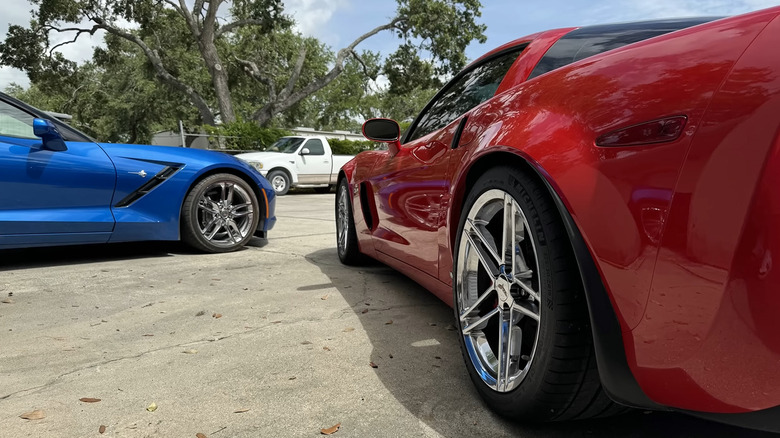 A blue and red corvette with staggered tires in a parking lot.