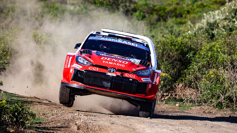 A front view of Toyota Yaris GR rally car driving on gravel road