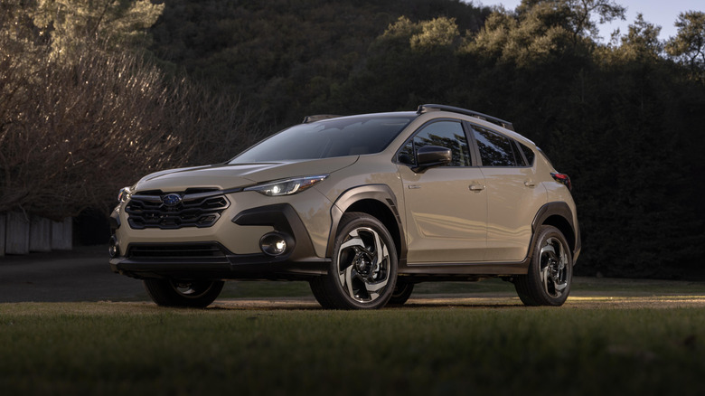 Front and left side view of a 2026 Subaru Crosstrek Hybrid parked on a scenic lawn