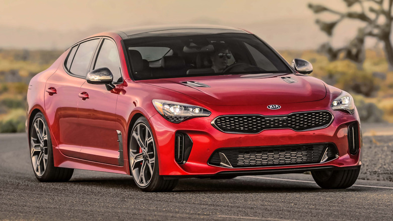 A front 3/4 view of a red 2021 Kia Stinger parked on a road
