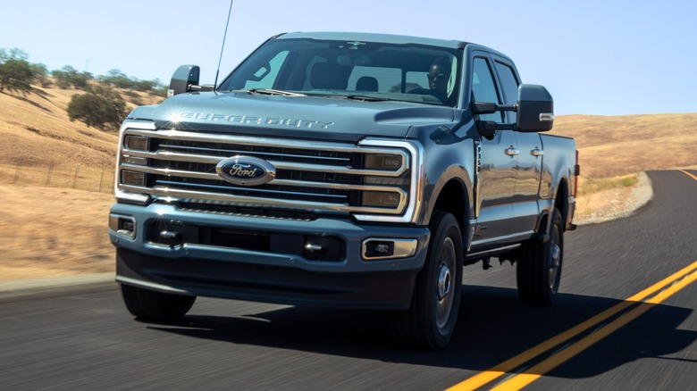 A front-quarter shot of a Ford Super Duty driving down a road