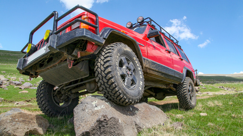 An off-road ready Jeep perched on a rock