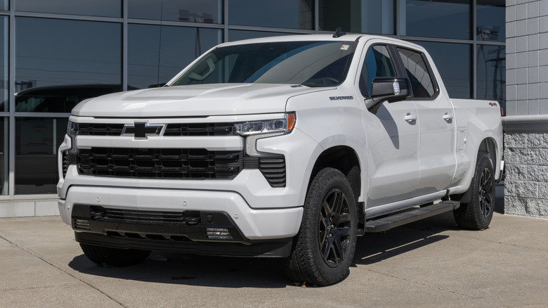 A white Chevrolet Silverado parked in front of an industrial building.
