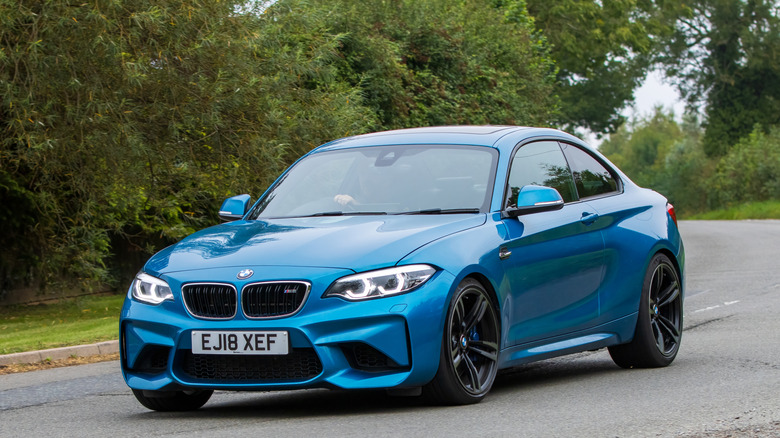 A blue 2023 BMW M2 parked on a street.