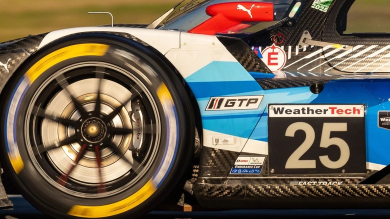 An IMSA WeatherTech SportsCar Championship race car wheel spins while Brembo brake caliper is shown.