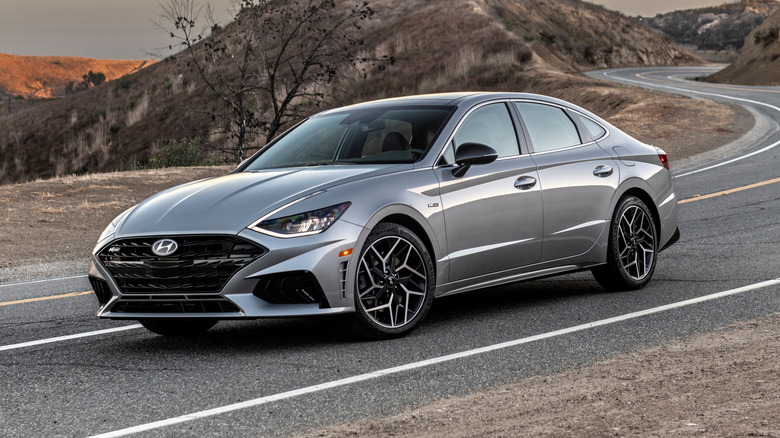 2022 Hyundai Sonata N Line parked on a paved road that curves through a hilly landscape