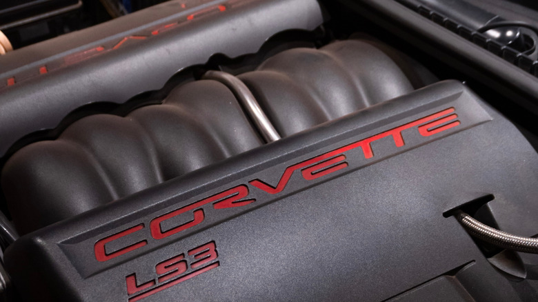 A GM LS3 engine under the hood of a Corvette with factory covers.