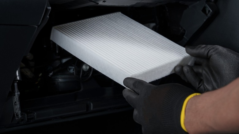 A technician installing new cabin filter