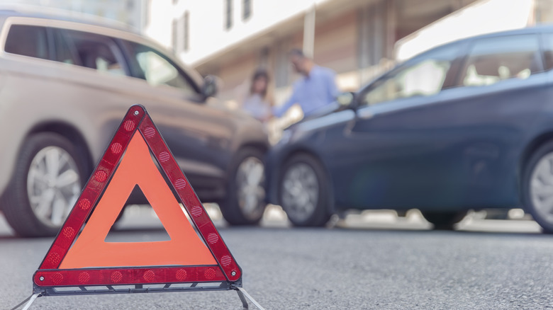 A warning triangle at the scene of a small car accident