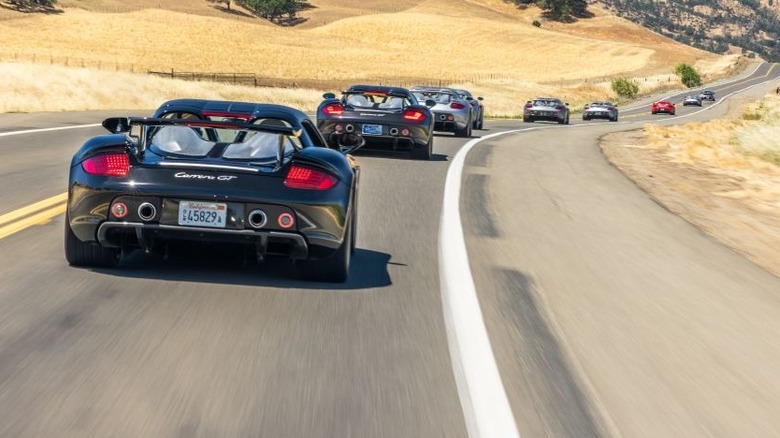 Several Porsche Carrera GTs on the road shot from the rear