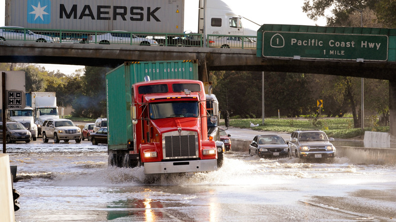 LONG BEACH, CA - JANUARY 19: Commercial trucks and cars make their way through the flooded north and southbound lanes of 710 Long Beach Freeway, the main artery to Long Beach and Los Angeles ports, on January 19, 2010 in Long Beach, California. A short but forceful storm moved through Southern California producing tornado-like winds in Huntington Beach and floods in Long Beach and San Pedro (Photo by Kevork Djansezian/Getty Images)