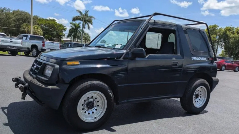 A black 1998 Chevrolet Tracker in a parking lot photographed at a slightly canted angle.