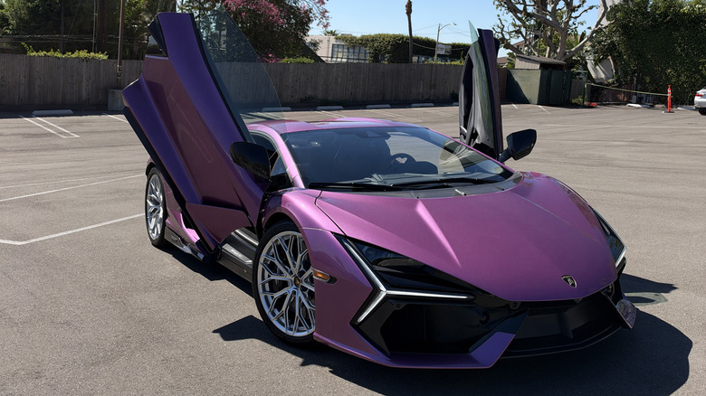 Front 3/4 view of a pink Lamborghini Revuelto with the doors open