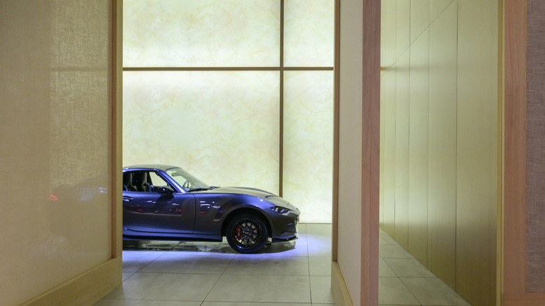 A Mazda MX-5 parked in a house, peaking around a corner