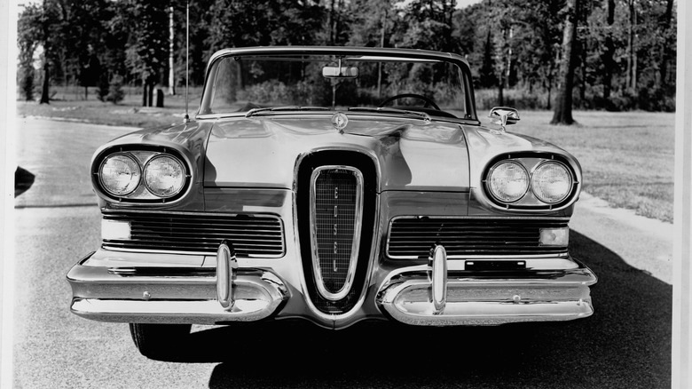 The Edsel parked in front of some trees in black and white