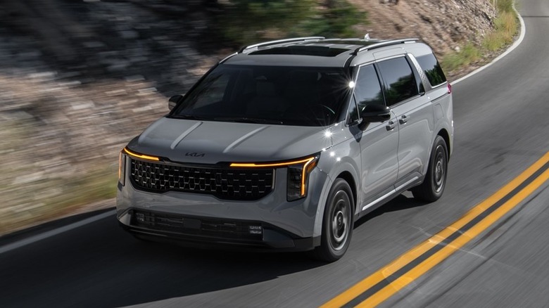 Front 3/4 view of a grey Kia Carnival