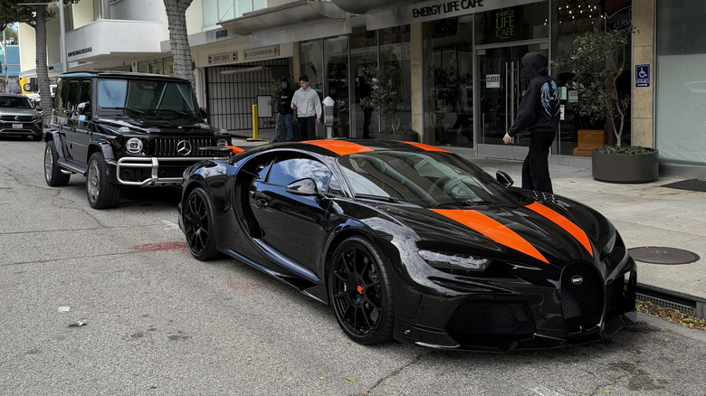 A black Bugatti Chiron Super Sport parked in front of a Mercedes G63