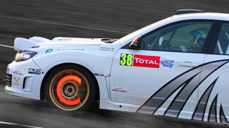 Subaru N14 rally car with glowing hot front brakes