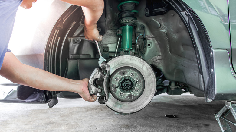 A mechanic servicing the brakes of a car