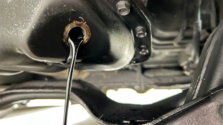 Old oil being drained from underneath an automobile