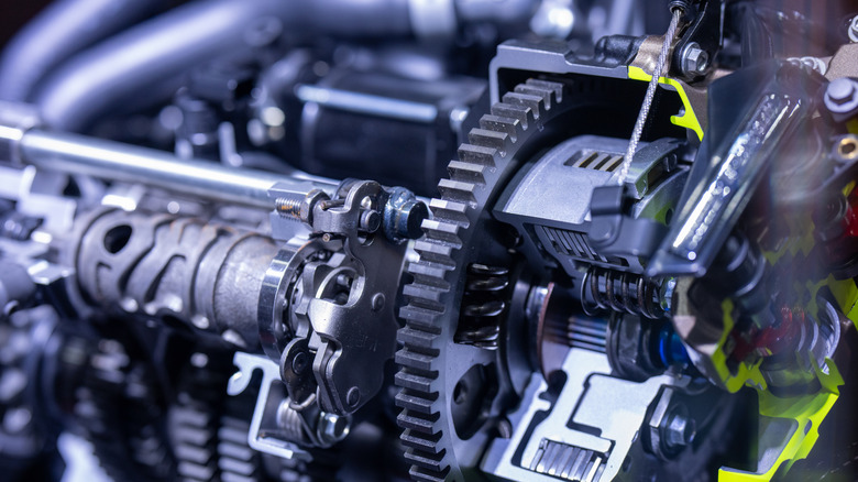 A close-up of a car engine gearbox, showing gears, sprockets, cogwheels, and bearings from the automotive transmission.