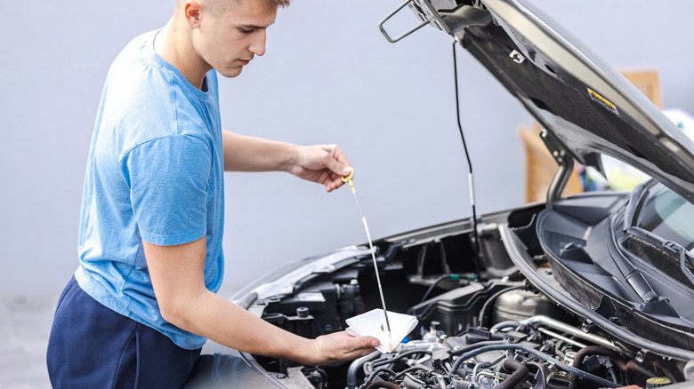 Man checking the oil level with a dipstick