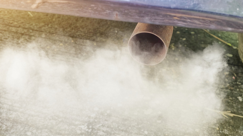 Car exhaust pipe spewing out billowy smoke