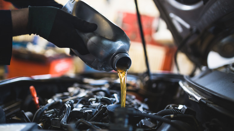 Mechanic pouring fresh oil into a car's engine