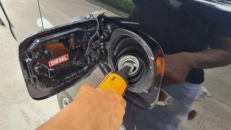 a driver fills a diesel additive into a car's diesel fuel tank