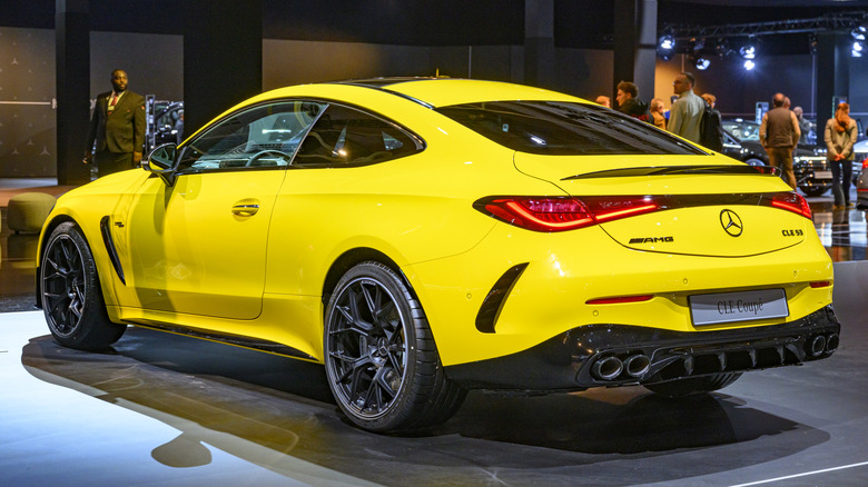 A rear three-quarter view of a yellow Mercedes AMG CLE 53 parked on display.