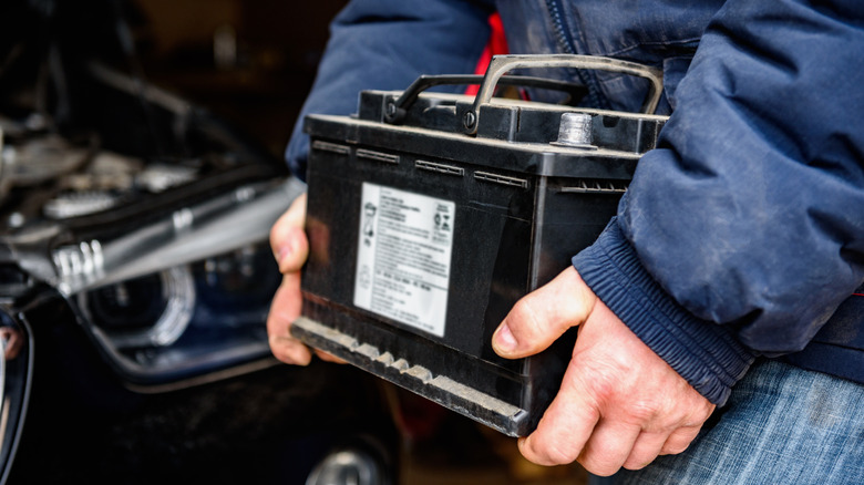 A car battery being held in arms