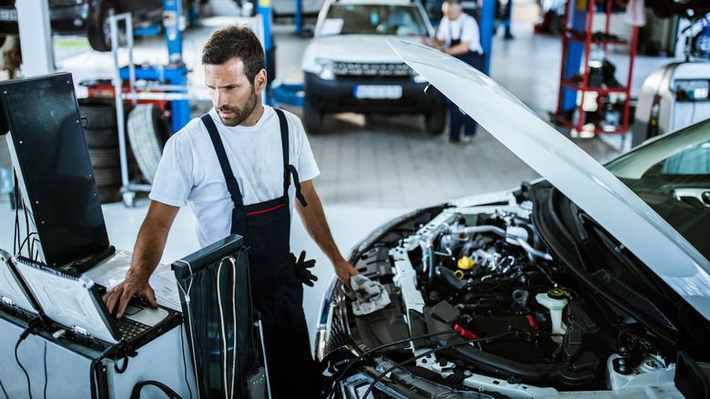 A technician reading data from a car
