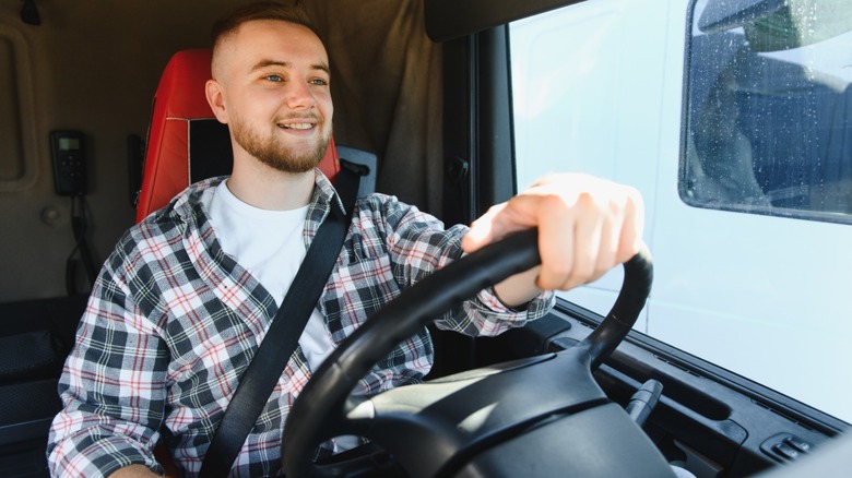 A young man driving a truck on a sunny day