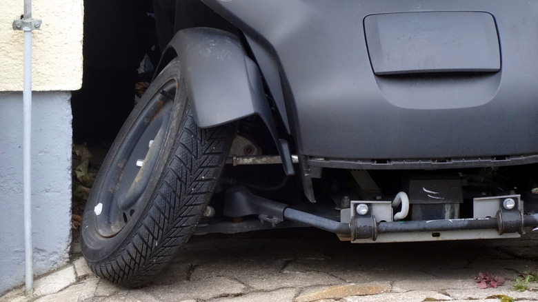 A car with a damaged axle and the front right tire at an odd angle