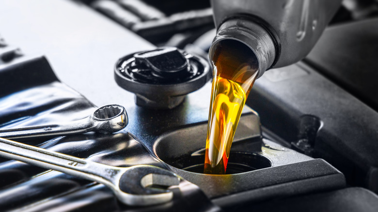 A close-up of oil being poured into an engine.