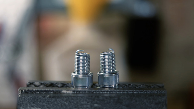 Side-by-side comparison between an unmodified spark plug (left) and a side gapped spark plug (right).