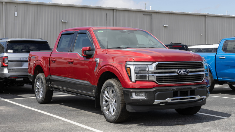 A red Ford F-250 King Ranch Edition parked in a dealership parking lot