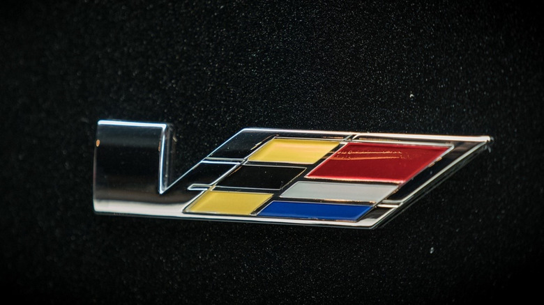 A closeup of the Cadillac V-series logo on a black CTS-V wagon