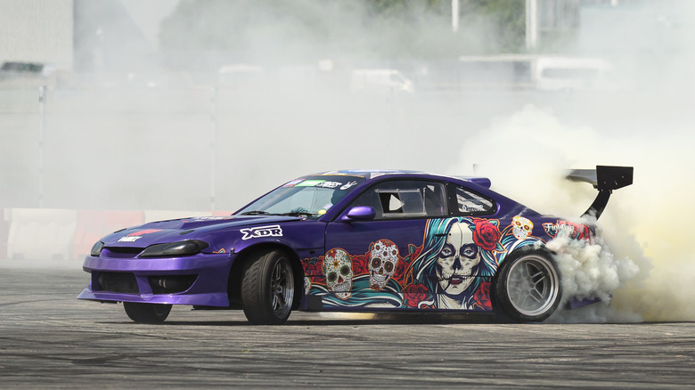 FARNBOROUGH, ENGLAND - AUGUST 17: A stunt driver takes part in a drifting exhibition during the first day of the British Motor Show at Farnborough International Exhibition Centre on August 17, 2023 in Farnborough, England. The UK's premier family-friendly automotive extravaganza is back with its annual showcase, featuring supercar parades, stunt shows, live auctions, expert advice on sustainable motoring options, and giving speed enthusiasts the chance to test drive the latest models.