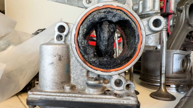 A close-up of a corroded exhaust valve filled with carbon deposits.