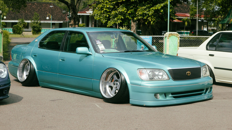 A heavily modified Lexus LS400 parked at a car show.
