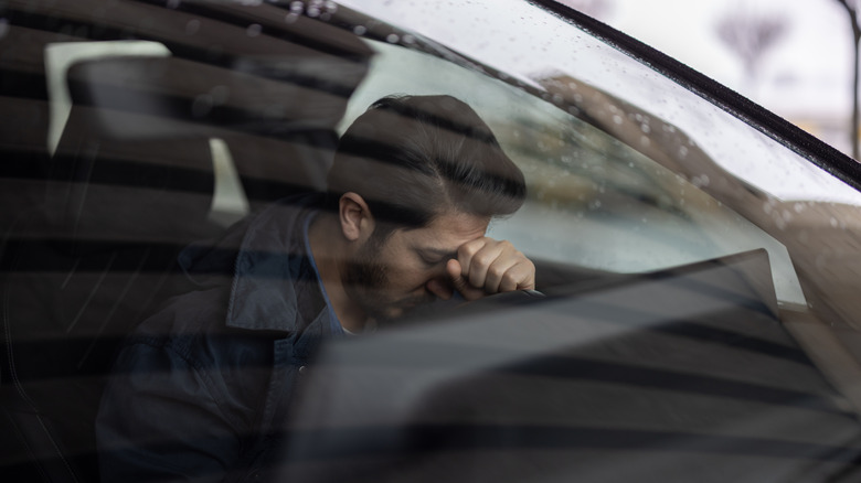 A distressed man inside his car
