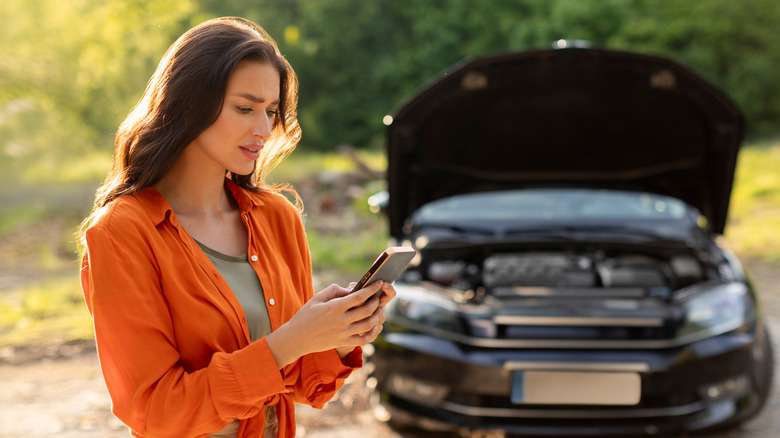 Woman stressed out over broken down car.