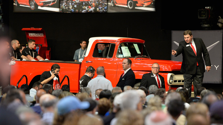 A red pickup truck being sold at a collector car auction