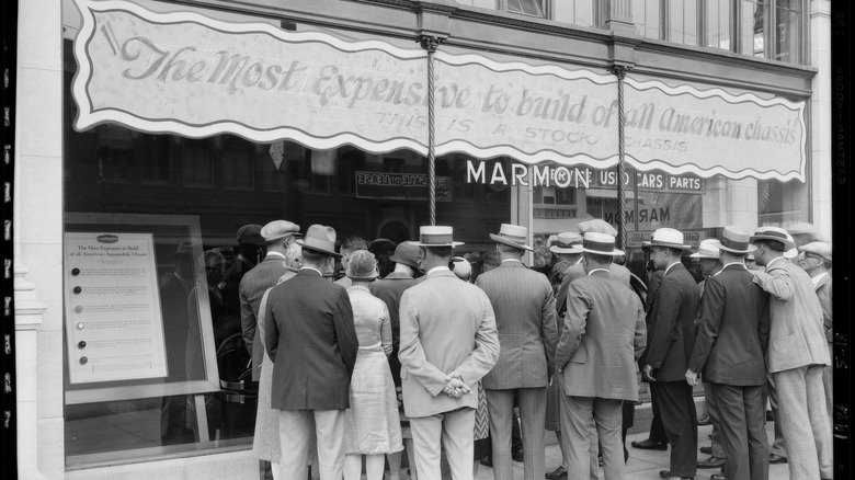 a group of people stand outside a car parts store